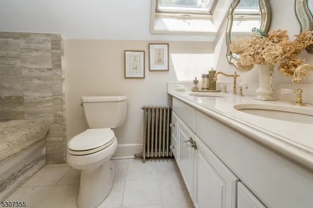 a bathroom with a granite countertop toilet sink and mirror