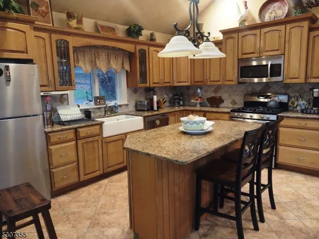 a kitchen with a sink a stove and chairs