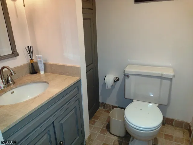 a bathroom with a granite countertop toilet and a sink