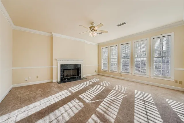 a view of an empty room with a fireplace and a window