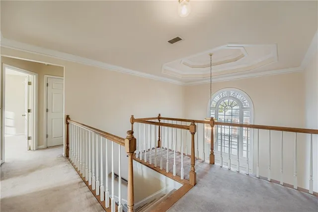 a view of staircase with railing and a chandelier