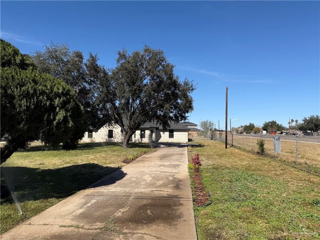 View of property hidden behind natural elements with driveway