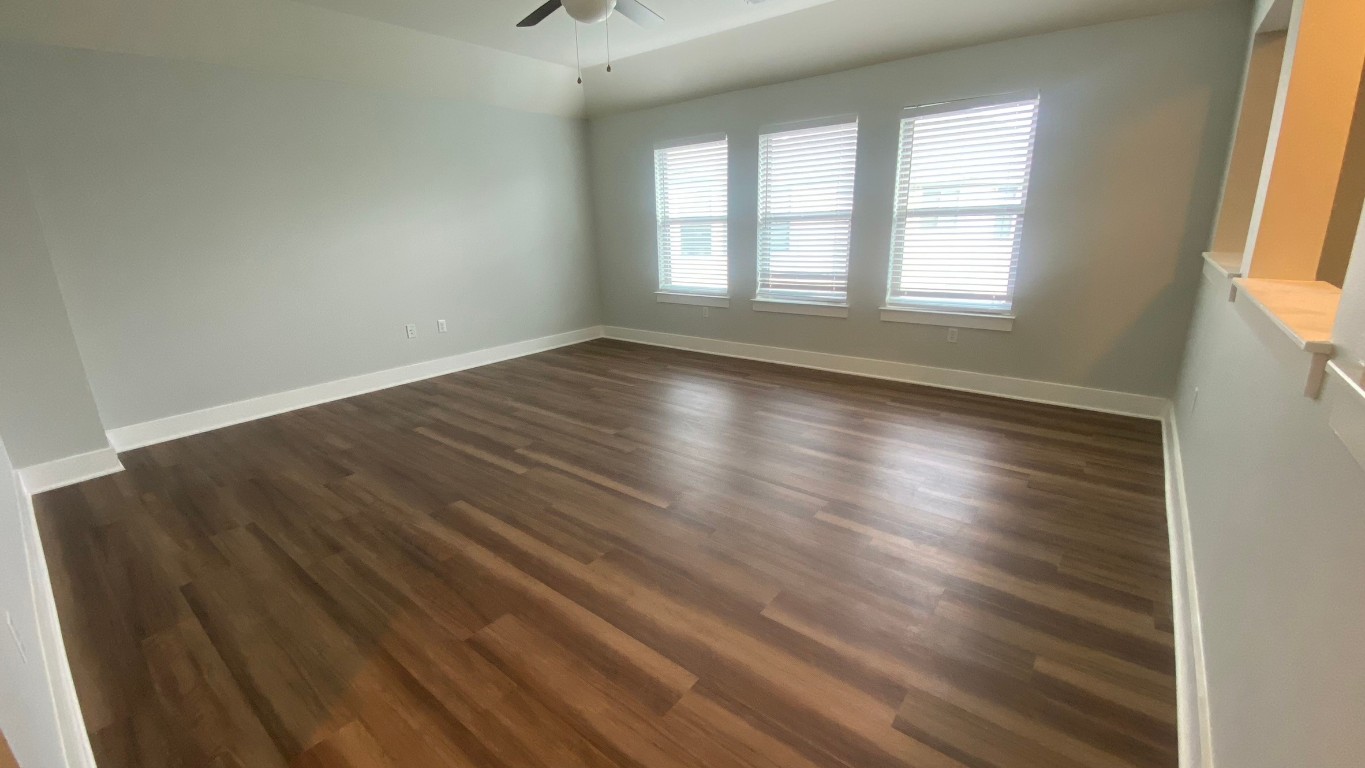 13001 Hymeadow Drive, Unit 36 Austin, TX 78729 - Photo 14 of 20 an empty room with wooden floor and windows