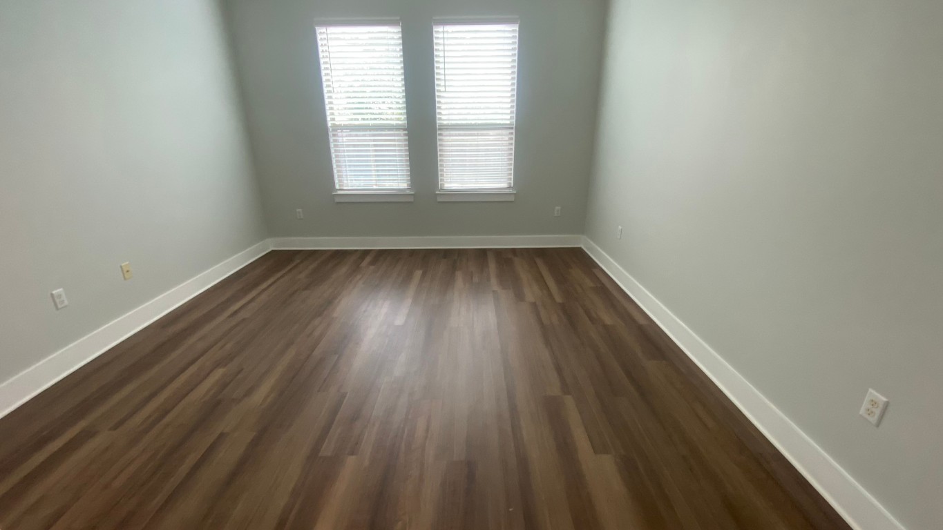 13001 Hymeadow Drive, Unit 36 Austin, TX 78729 - Photo 17 of 20 an empty room with wooden floor and windows