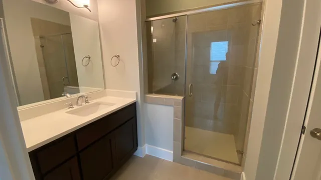a bathroom with a double vanity sink a toilet and shower