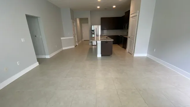 a view of kitchen with refrigerator and wooden floor