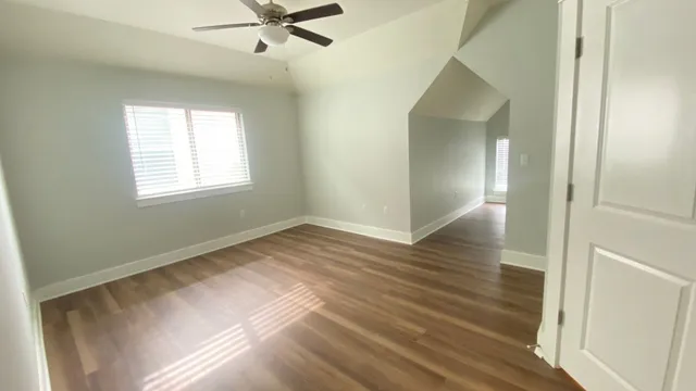a view of a livingroom with wooden floor and a ceiling fan