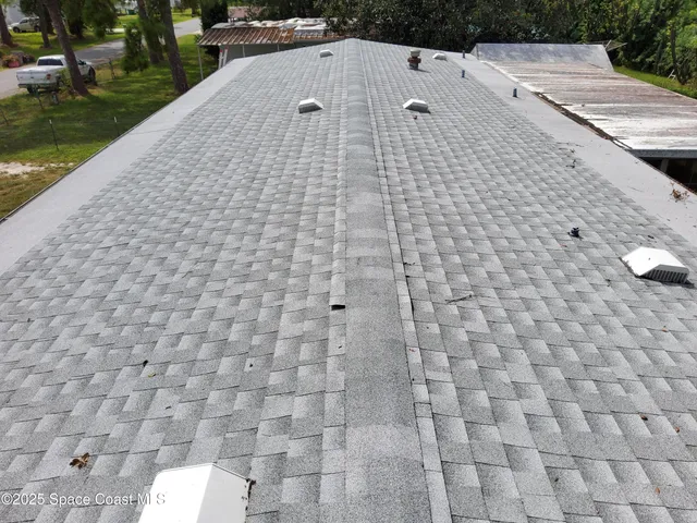a view of a house with a large windows and plants