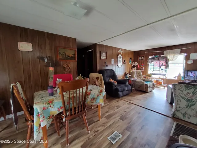a living room with furniture a dining table and a large window
