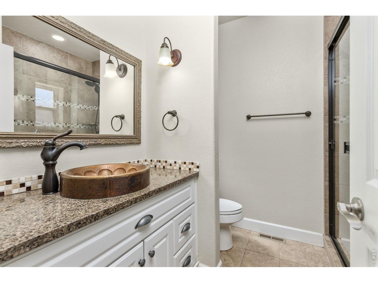 2002 Trail Ridge Drive Severance, CO 80615 - Photo 24 of 50 The primary suite has a fully updated bathroom with tile flooring, quartz countertops, and large tile shower.