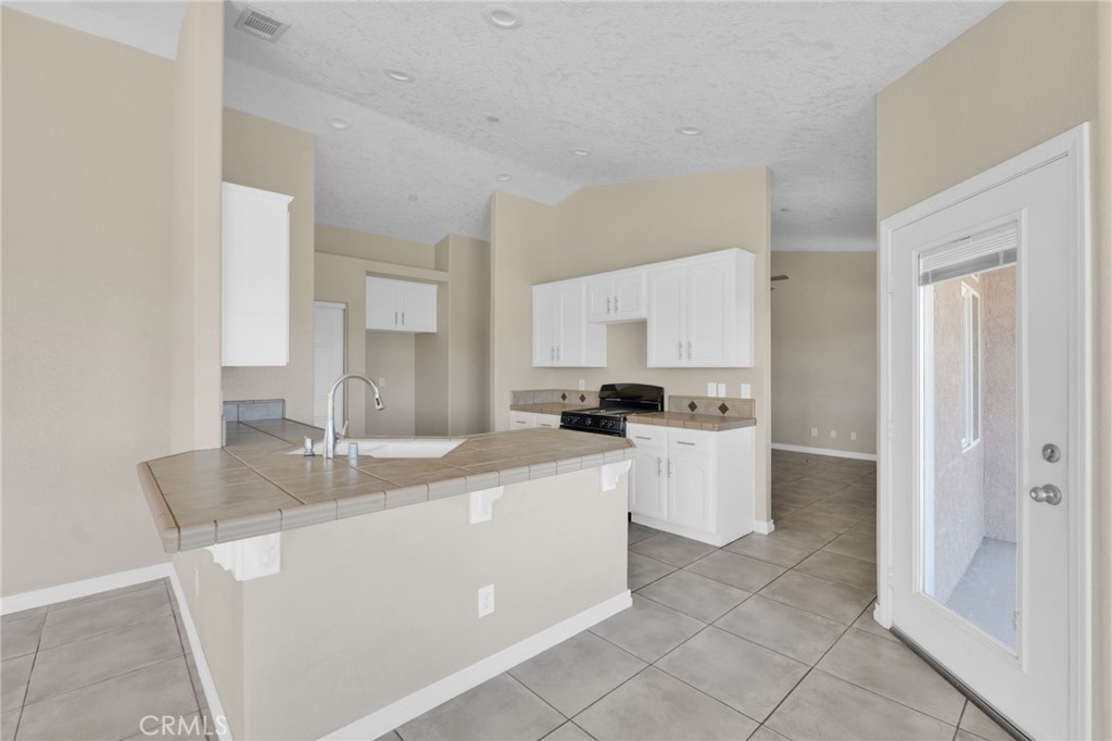 12865 Barbet Road Phelan, CA 92371 - Photo 13 of 51 a kitchen with white cabinets and white appliances