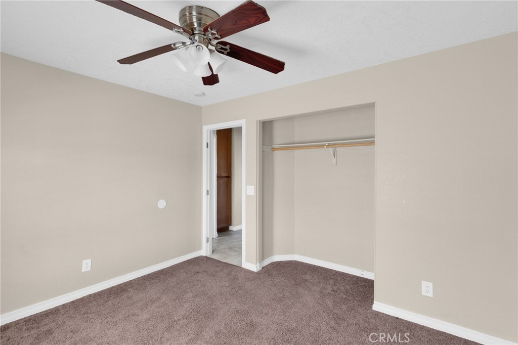 12865 Barbet Road Phelan, CA 92371 - Photo 19 of 51 an empty room with closet and a ceiling fan