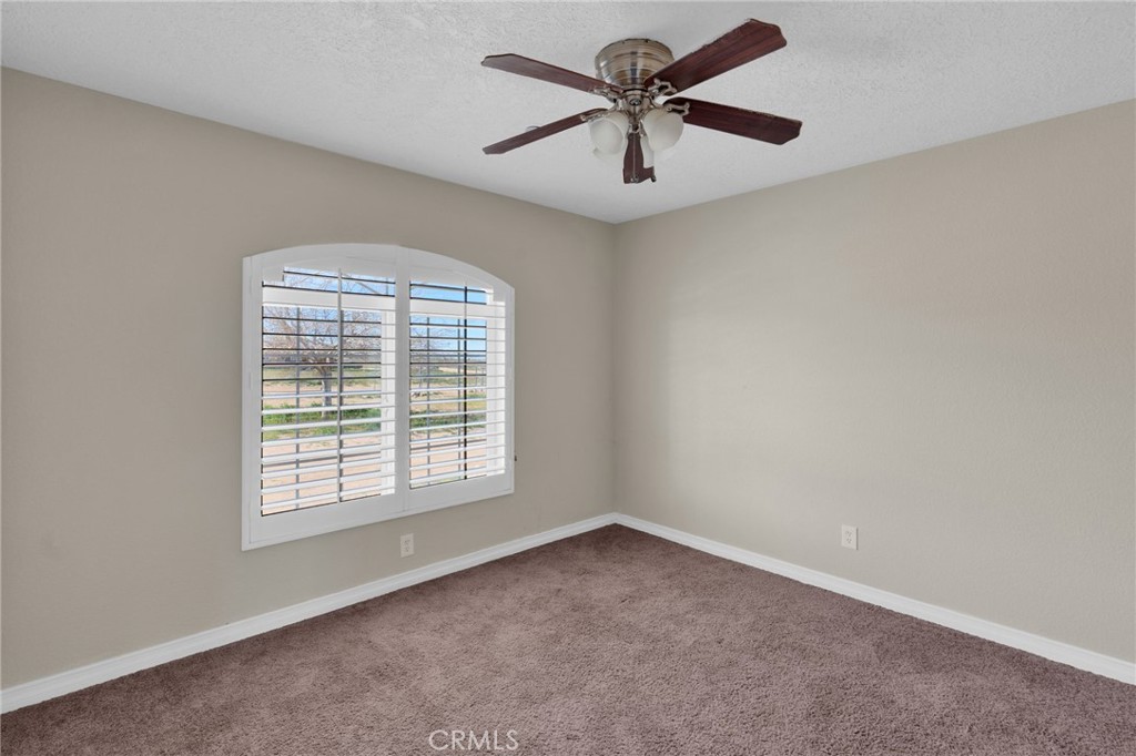 12865 Barbet Road Phelan, CA 92371 - Photo 20 of 51 an empty room with a window and a fan