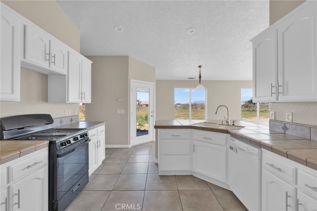 12865 Barbet Road Phelan, CA 92371 - Photo 10 of 51 a kitchen with a sink stove top oven and cabinets