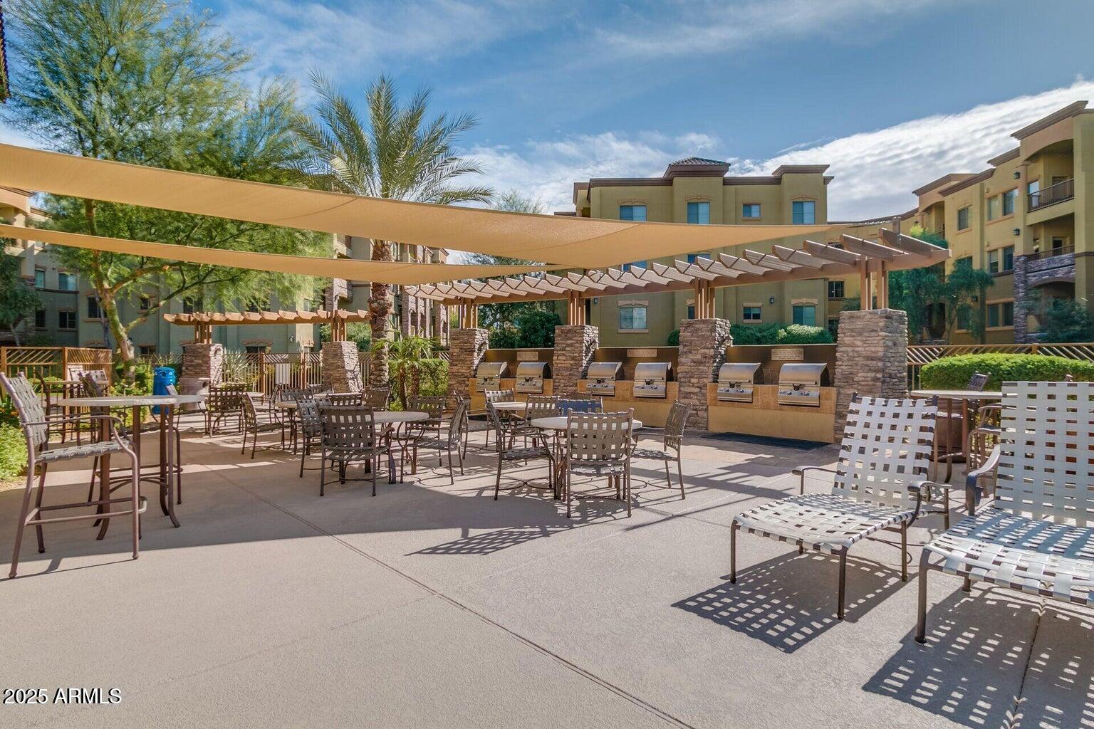 5450 East Deer Valley Drive, Unit 1208 Phoenix, AZ 85054 - Photo 30 of 36 a view of a patio with a table and chairs and potted plants