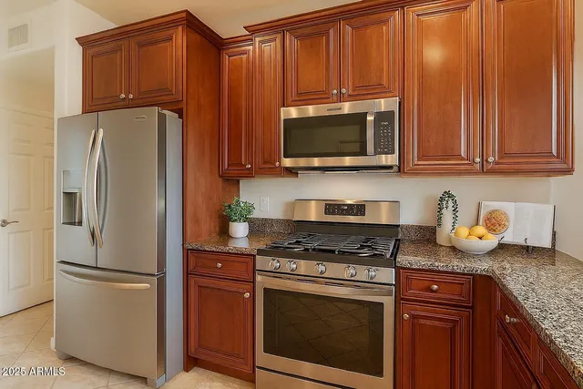 a kitchen with granite countertop wooden cabinets and a stainless steel appliances