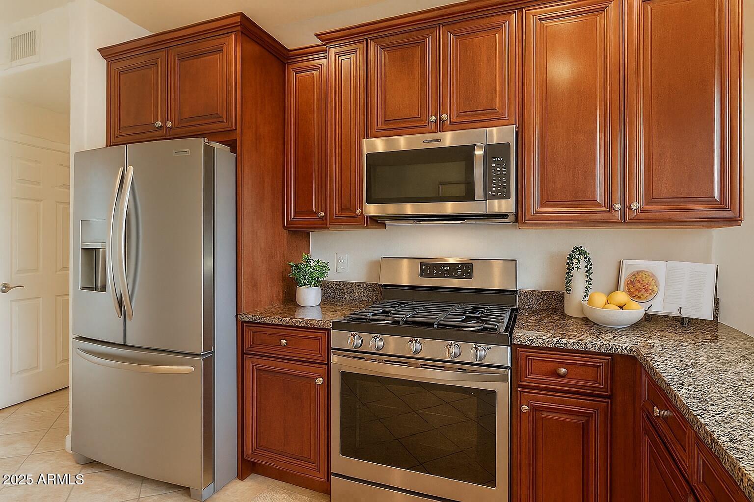 5450 East Deer Valley Drive, Unit 1208 Phoenix, AZ 85054 - Photo 4 of 36 a kitchen with granite countertop wooden cabinets and a stainless steel appliances