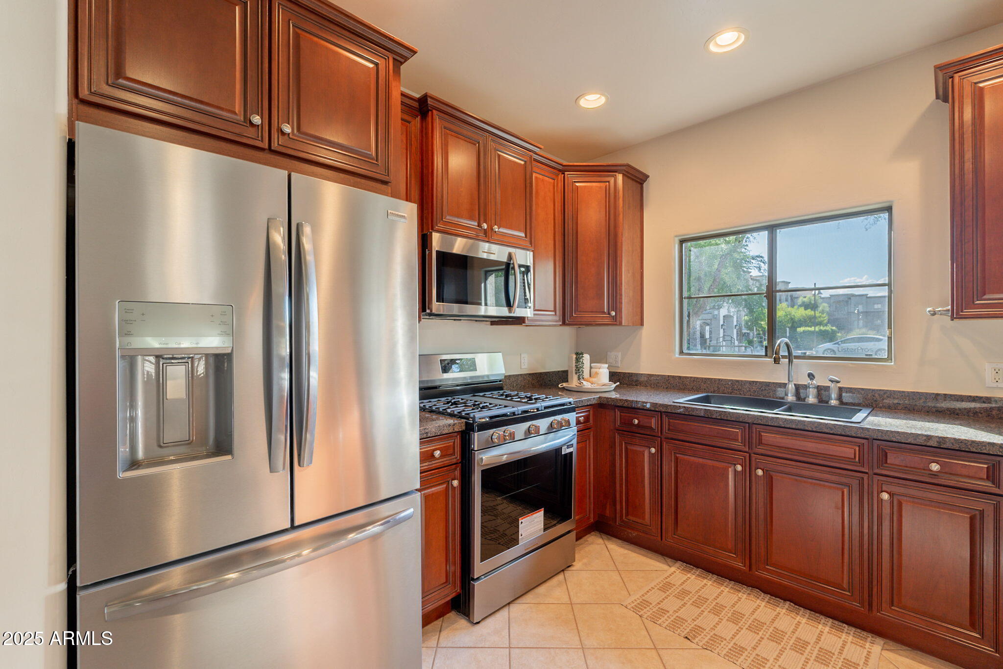 5450 East Deer Valley Drive, Unit 1208 Phoenix, AZ 85054 - Photo 9 of 36 a kitchen with stainless steel appliances granite countertop a refrigerator a sink dishwasher a stove top oven a refrigerator with wooden cabinets and floor