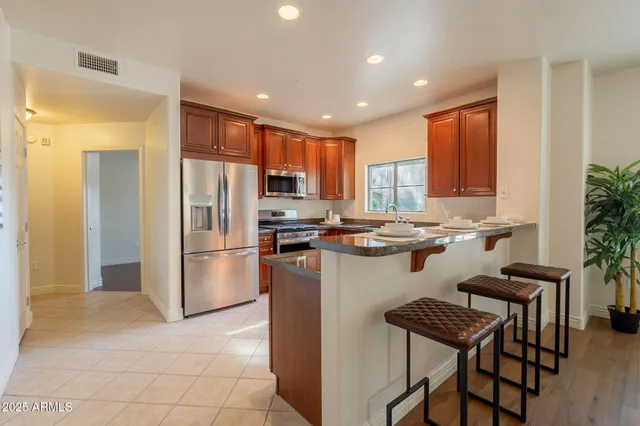 a kitchen with a refrigerator a counter top space and a center island
