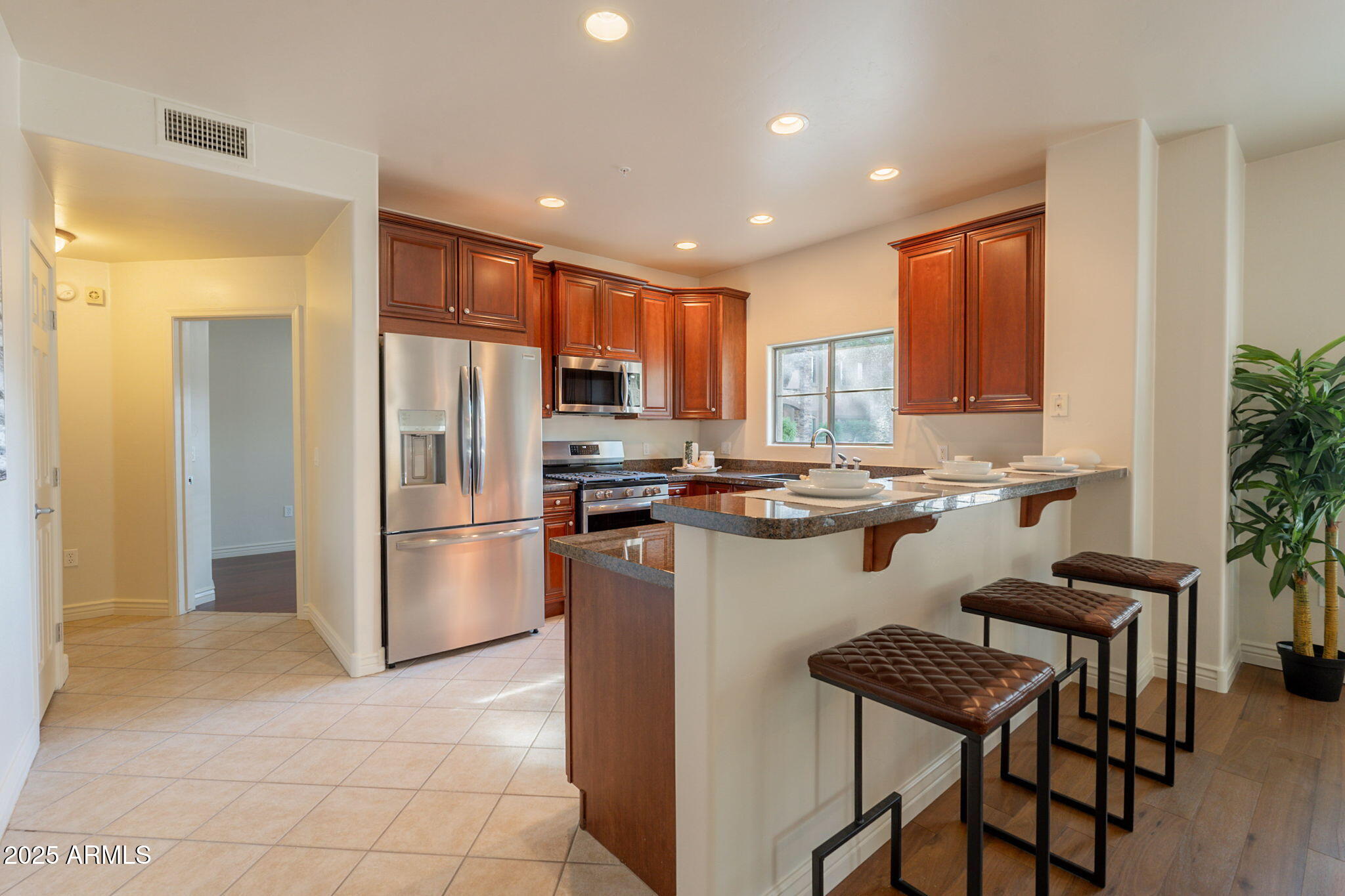 5450 East Deer Valley Drive, Unit 1208 Phoenix, AZ 85054 - Photo 10 of 36 a kitchen with a refrigerator a counter top space and a center island
