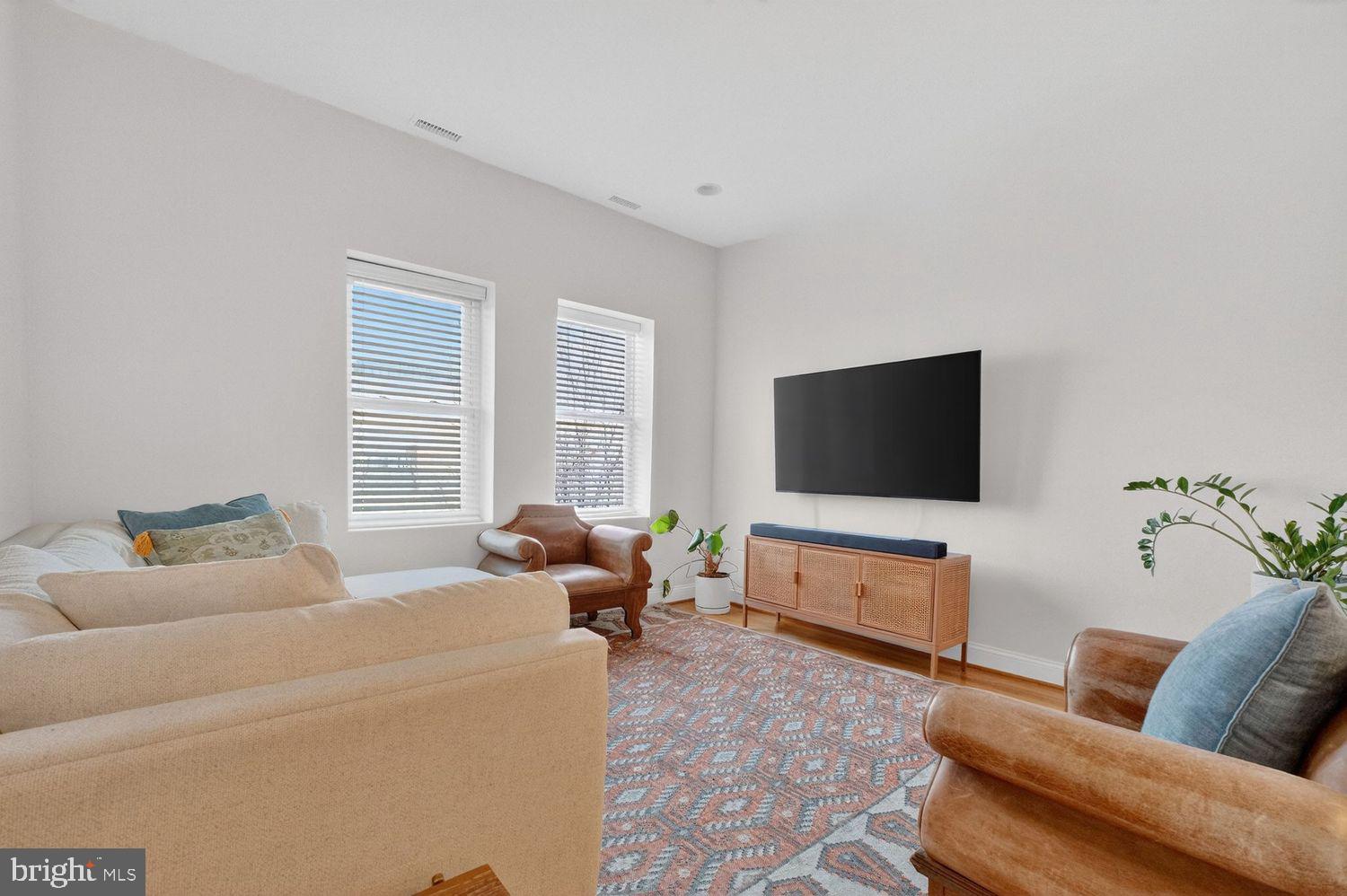 219 T Street Northeast, Unit 404 Washington, DC 20002 - Photo 3 of 24 a living room with furniture and a flat screen tv