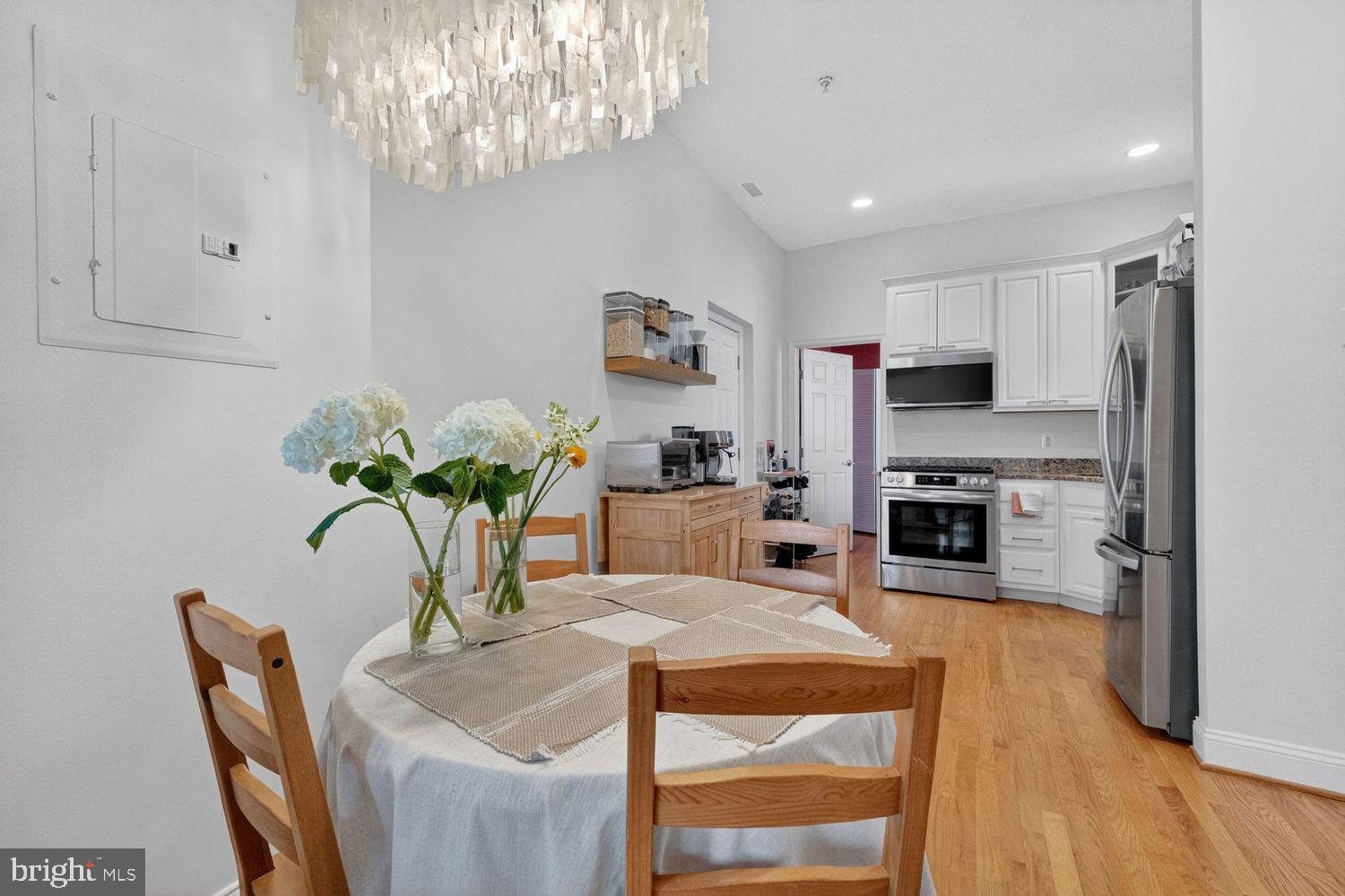 219 T Street Northeast, Unit 404 Washington, DC 20002 - Photo 9 of 24 a dining room with furniture a chandelier and kitchen view