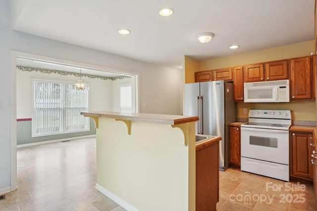 a kitchen with stainless steel appliances a refrigerator and a stove top oven