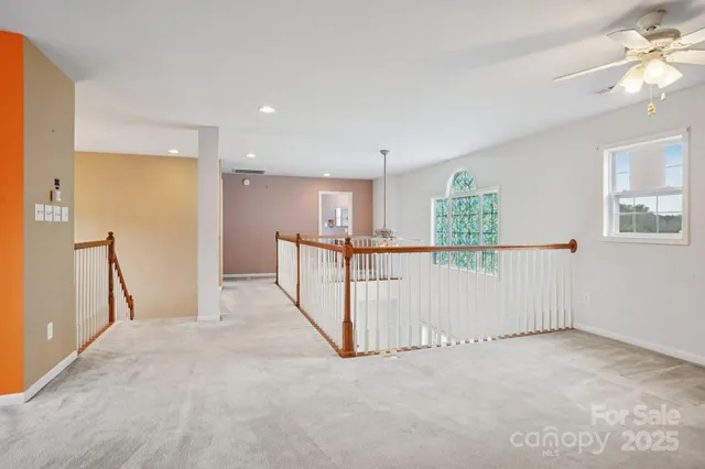 a view of a hallway with wooden floor and windows
