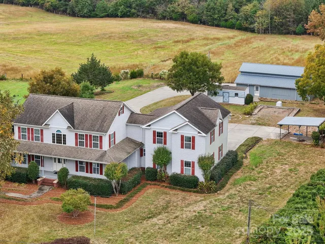 an aerial view of residential houses with outdoor space and ocean view