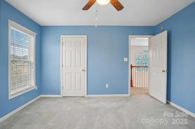 an empty room with closet and windows