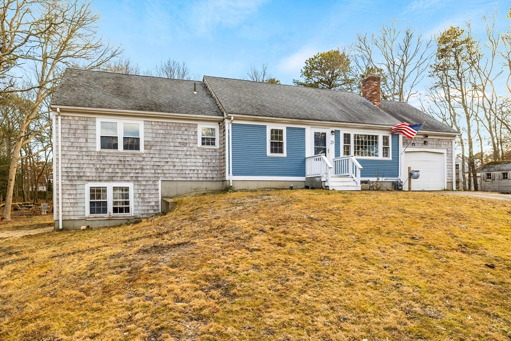 29 Butternut Circle Barnstable, MA 02635 - Photo 2 of 38 a front view of house with yard and trees in the background