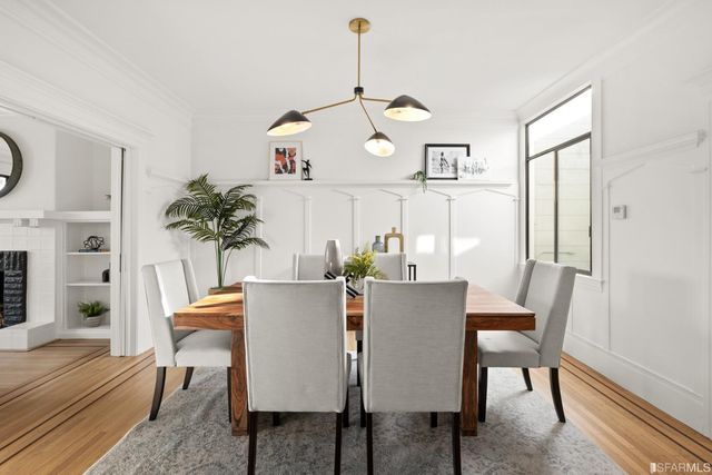 a view of a dining room with furniture wooden floor and a chandelier
