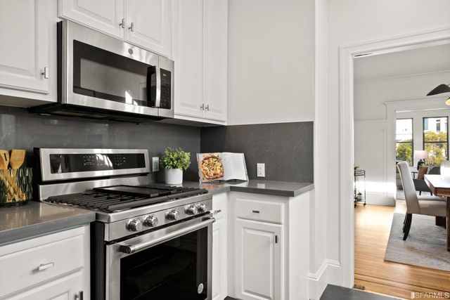 a kitchen with stainless steel appliances granite countertop a stove microwave and cabinets