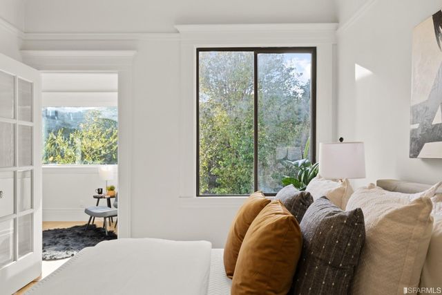 a bed sitting in a bedroom next to a window