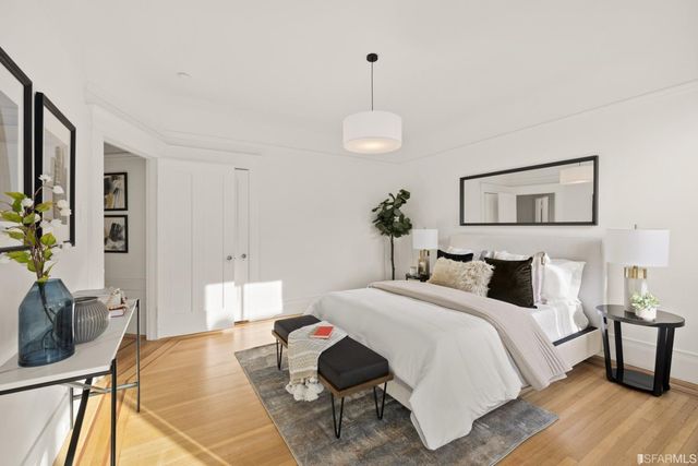 a bedroom with a bed and wooden floor