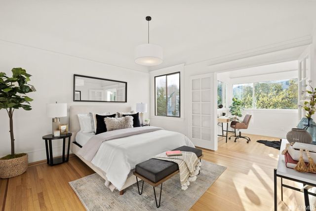 a spacious bedroom with a bed a chandelier and a window