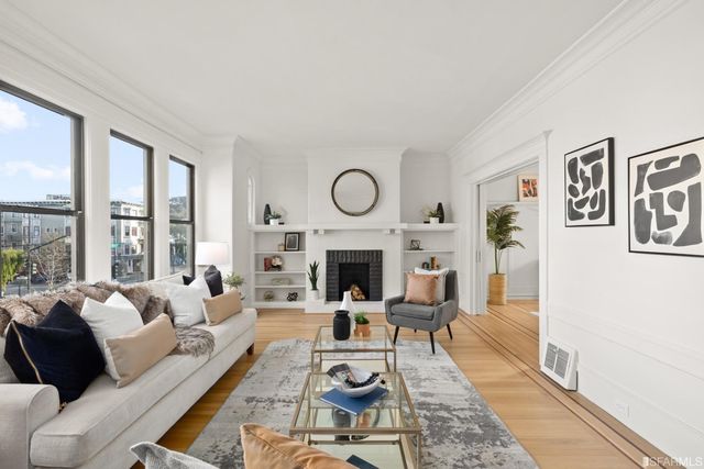 a living room with furniture a fireplace and a floor to ceiling window