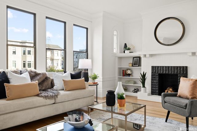 a living room with furniture a fireplace and a large window