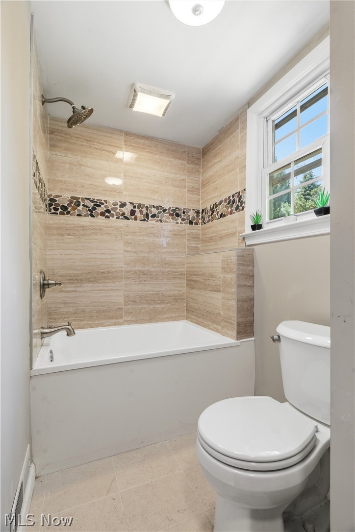 1769 Paradise Road Orrville, OH 44667 - Photo 18 of 36 Bathtub with floor-to-ceiling textured tile surround, pebble accent band, and brushed nickel fixtures