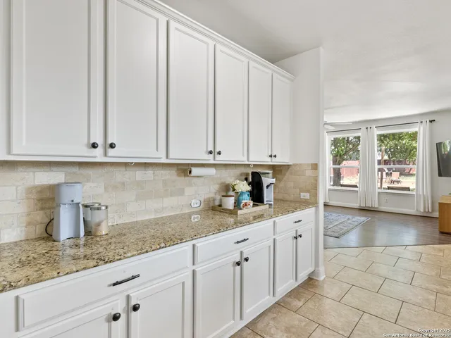 a kitchen with granite countertop white cabinets and white appliances