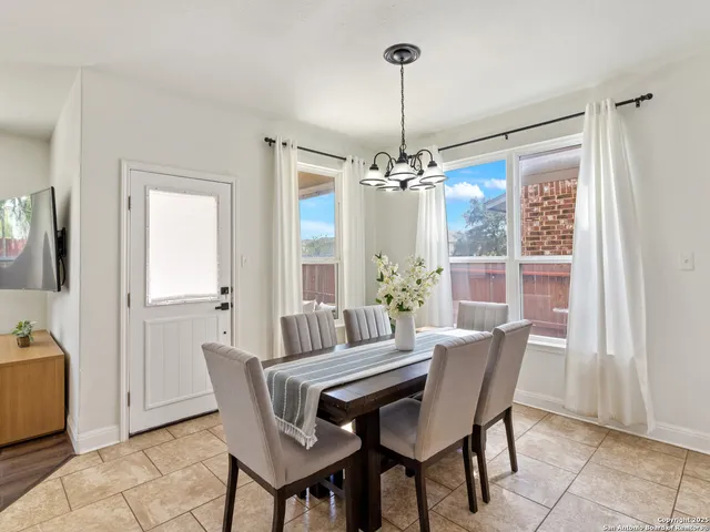 a view of a dining room with furniture and chandelier