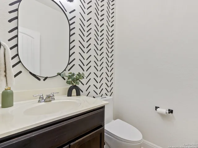 a bathroom with a sink mirror vanity and toilet