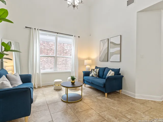 a living room with furniture and a potted plant