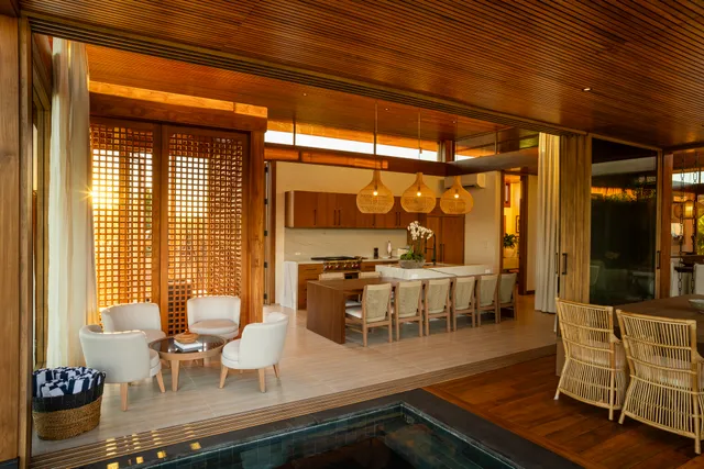 a dining room with wooden floor and large windows