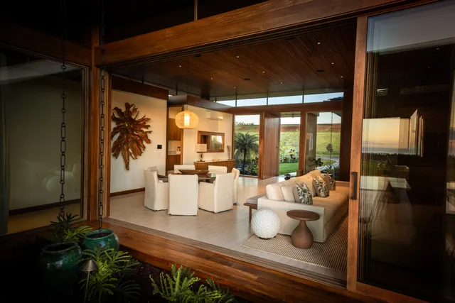 a living room with patio furniture and floor to ceiling window