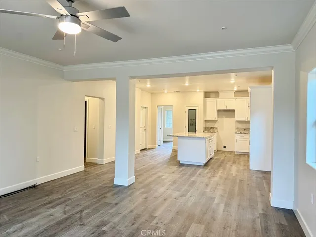 a room with kitchen island stainless steel appliances furniture and a large window