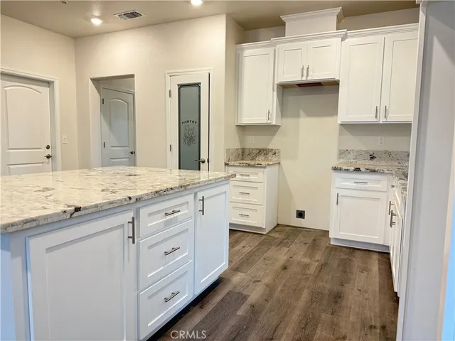 a kitchen with granite countertop white cabinets and white appliances