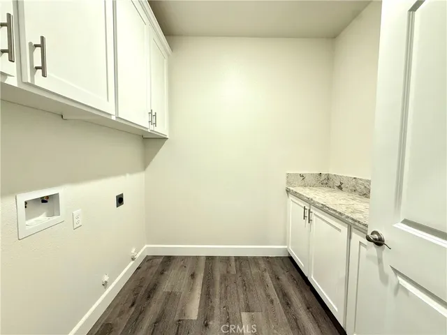 a view of a kitchen with white cabinets and wooden floor