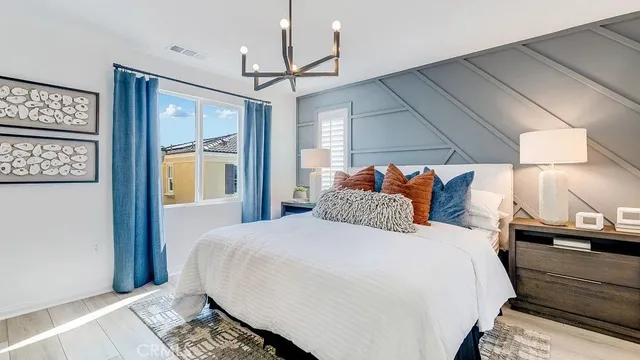 a bedroom with a bed and a lamp on dresser