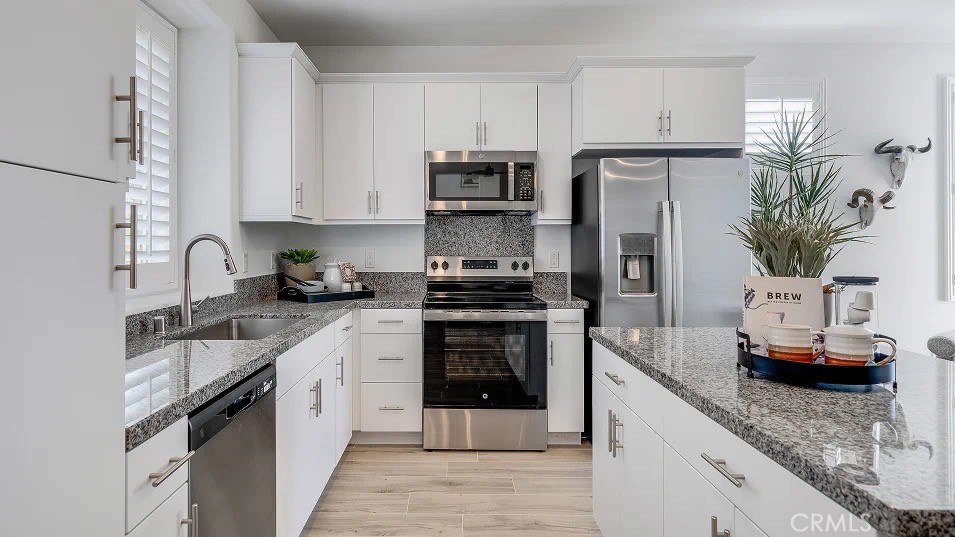 1209 Yeager Avenue Rialto, CA 92376 - Photo 3 of 20 a kitchen with stainless steel appliances granite countertop a refrigerator sink stove and white cabinets